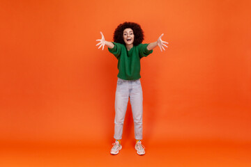 Come to my arms! Full length of friendly young adult woman with Afro hairstyle wearing green casual...