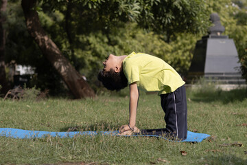 Yoga kid Practicing Yoga Outdoors in the park in Morning, healthy lifestyle concept