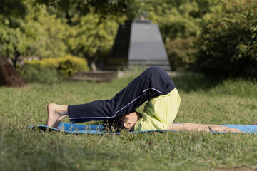 Young boy Practicing Yoga Outdoors in the park in Morning, healthy lifestyle concept, Kids yoga