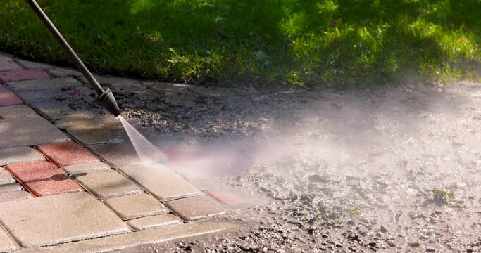dirty block pavement cleaning with high pressure washer. slider shot