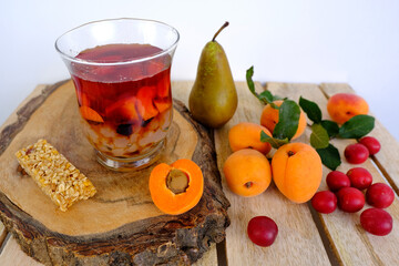 fresh juice fruit and berry low-calorie dessert in glass with bubble tea, ripe apricots, cherry plums, pears, muesli bar, concept of healthy eating, vegan diet, raw food, healthy food