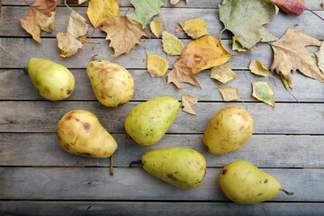 Pears on a wooden table decorated with autumn leaves