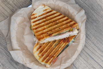 Overhead view of grilled panini sandwich, with chicken and mayo on sour dough bread