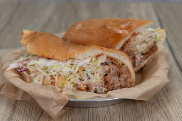 Tempting BBQ pulled pork sandwich with lettuce and pickle served on a freshly baked Italian roll