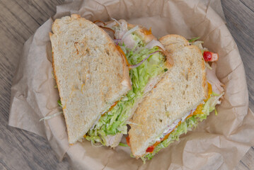 Overhead view of grilled roasted turkey sandwich with meat, provolone cheese, and mayo on sour dough bread