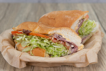 Loaded ham sandwich with provolone cheese, tomato, mayo, and red onion inside an Italian Roll for a hearty lunch meal.