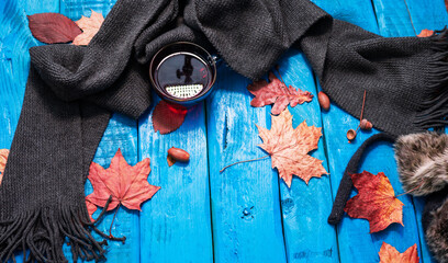 op view copy space background of autumn with a cup of tea on a vintage table, yellow leaves fall on the table, cozy warm autumn background with tea silk scarf and leaves.