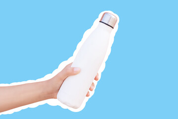 Reusable thermo water bottle in hand, isolated with white contour on blue.