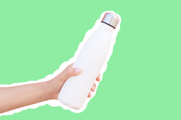 Reusable thermo water bottle in hand, isolated with white contour on green.