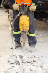 Crusher machine breaking concrete floor at work.