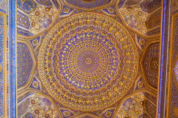 SAMARQAND, UZBEKISTAN - JUNE 09, 2022: Ceiling with gold and blue colors of the Tillya-Kori Madrasah in the centre of Samarqand in Uzbekistan.
