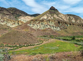 The John Day River flows below Sheep Rock at the John Day Fossil Beds National Monument in Oregon, USA
