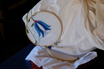 A close-up of a white cloth with a Kashubian embroidery on the hoop. - obrazy, fototapety, plakaty