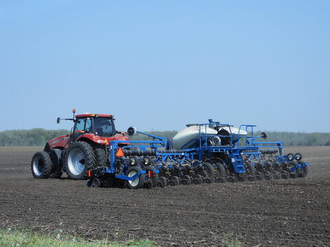 Oglesby, Illinois - USA - May 12, 2022; Case 315 tractor pulling a Kinze pivot fold 16 row planter