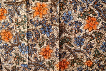 Braun-beige Stofffläche mit orange-blauem Blumenmuster 