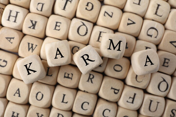 Many cubes with letters and some of them making word Karma, top view