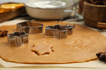 Dough and cookie cutters on table, closeup