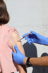 young student during the vaccination against the virus and the syringe with the liquid used by the...