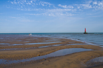 two people walking on a beach
