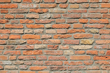 wall made of many red bricks with mortar of an old house