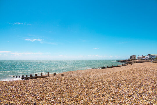 Shades of blue. A day in the british south coast, in Felpham, near brighton. View of the beach of pebbles or rocks ,bright blue sea and sky, sunny day. Beautiful summer day in Britain.