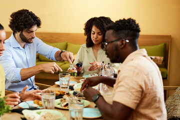Group of four friends eating lunch in a restaurant. Reunion and celebration concept.