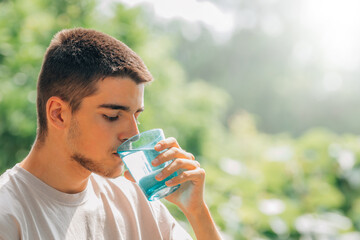 young man drinking water outdoors