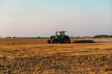 Tractor plowing the field after harvest.