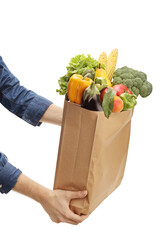 Male hands holding a paper bag with fruits and vegetables
