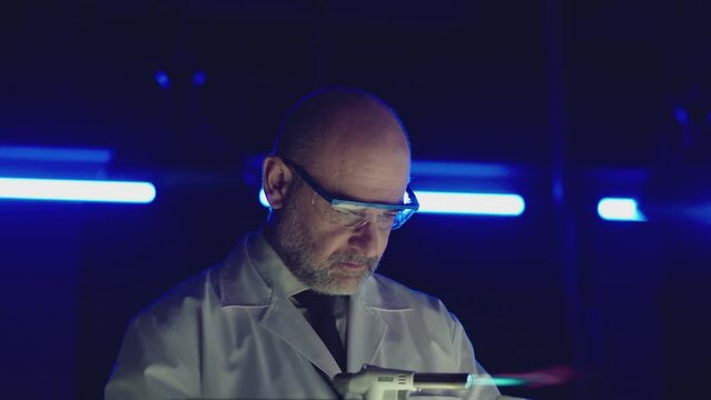 Professional tester testing , burning piece of fireproof building material  by gas torch inside  futuristic laboratory.  Construction engineer doing experiment . Physicist working in lab . Slow motion
