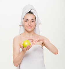 beauty portrait of a cheerful girl with a towel on her head isolated.Facial skin care and health concept.close-up on a white background. girl holding a glass holding an apple brushing her teeth making