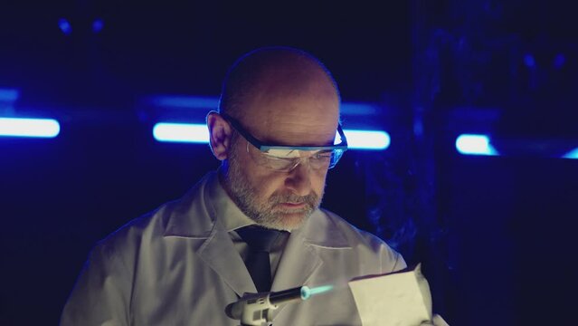Professional tester testing , burning piece of fireproof building material by gas torch inside futuristic laboratory. Construction engineer doing experiment . Physicist working in lab . Slow motion