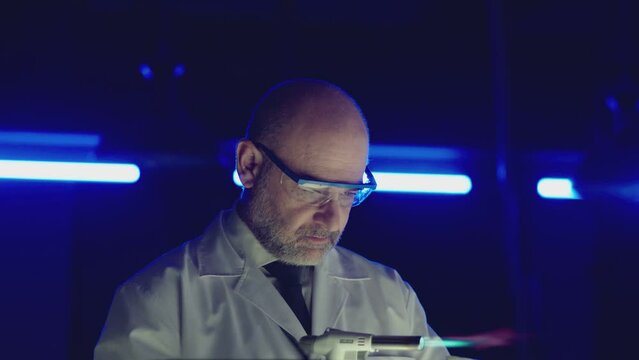 Professional tester testing , burning piece of fireproof building material by gas torch inside futuristic laboratory. Construction engineer doing experiment . Physicist working in lab . Slow motion