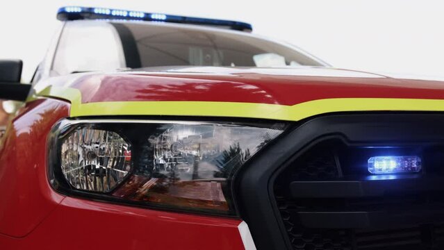 Police car standing, getting ready for ride to emergency call with lights flashing, a low profile, overhead police light bar flashes during the day.