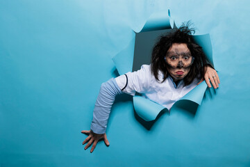 Crazy laughable scientist with amusing expression, dirty face and messy hair acting funny after...