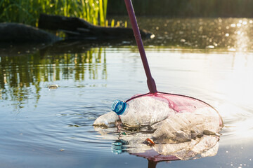 collecting plastic garbage on the beach or on the shore of a reservoir, the concept of cleaning the...