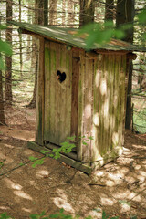 Wooden toilet outside in the forest.