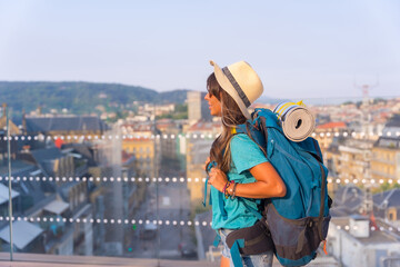 Just arrived in the city a traveler girl with a travel backpack enjoying the vacations