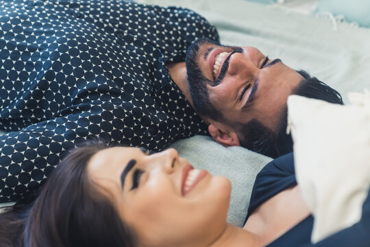 Heterosexual interracial couple lying down on bed. Happy relationship concept. Handsome Cuban bearded guy and his girlfriend. High quality photo