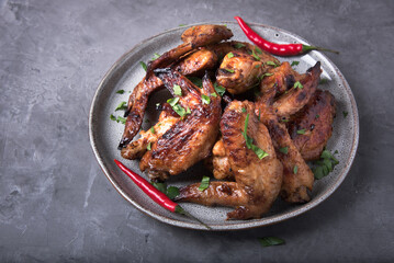 Barbecue chicken wings on grey background 