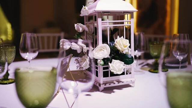 There are beautiful flowers and a small decorative gazebo on the festive table. Shooting jewelry close-up