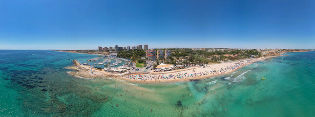 Panoramic view of Dehesa de Campoamor beach, Alicante during sunny summer day. Costa Blanca. Spain. Travel and tourism concept.
