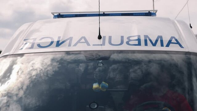 The ambulance van on a wide city street has warning lights and sirens, a Metropolitan rescue vehicle, responding in hazardous conditions, a close-up front view of the ambulance.