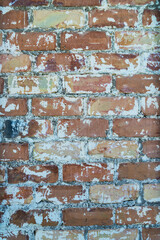 aged red brick wall with remaining patches of plaster and lime