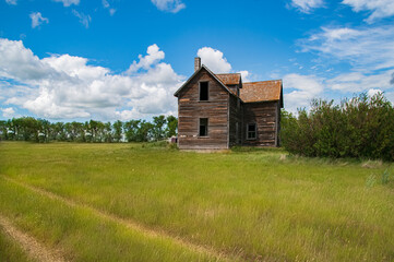 Fototapeta na wymiar Old Abandoned Rural Farmhouse In A Grass Yard