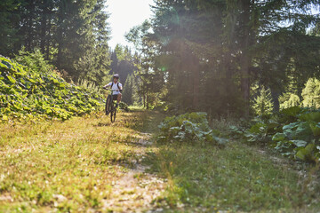 A cyclist rides a bike on extreme and dangerous forest roads. Selective focus