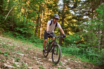 Fototapeta na wymiar A cyclist rides a bike on extreme and dangerous forest roads. Selective focus