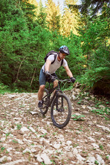 Naklejka premium A cyclist rides a bike on extreme and dangerous forest roads. Selective focus