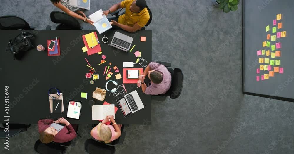 Aufkleber Group of diverse colleagues using technology sitting in a corporate workplace from above. Bright informal office space to improve creativity. Creative spot for staff to relax and browse the internet