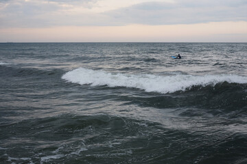 beautiful seascape storm on the sea cloudy sky in the water a surfer swims